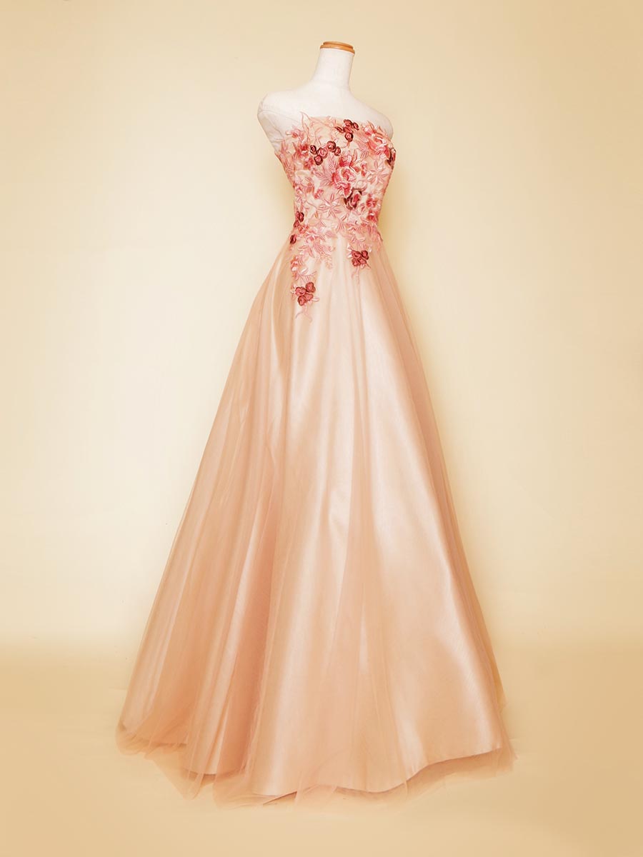 ピンクカラーの花柄刺繍をトップにベージュのサテンを下地に加えたスッキリフォルムのステージロングドレス