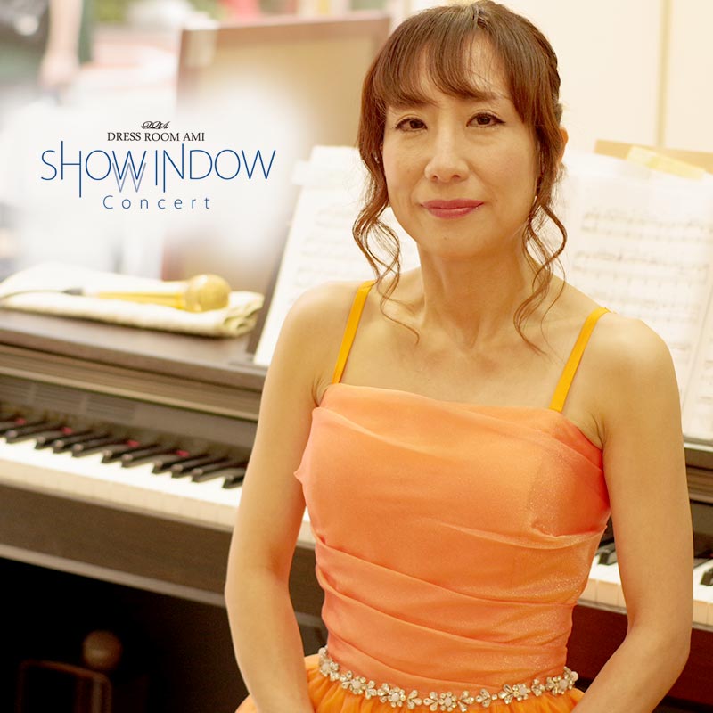 夏らしいオレンジカラーのステージドレスを身にまとったピアニストのショーウィンドコンサート